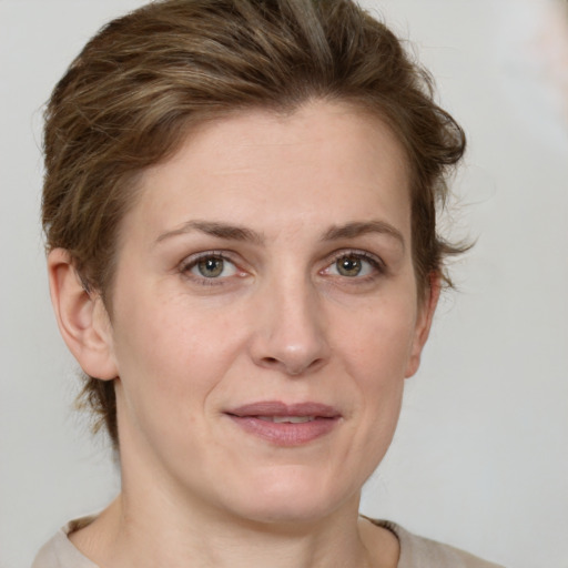 Joyful white adult female with medium  brown hair and grey eyes