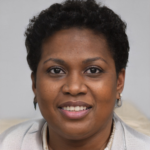 Joyful black young-adult female with short  brown hair and brown eyes