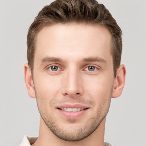 Joyful white young-adult male with short  brown hair and grey eyes