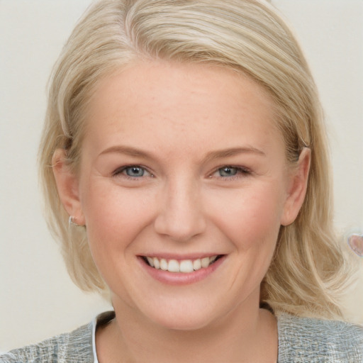 Joyful white young-adult female with medium  blond hair and blue eyes