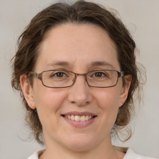 Joyful white adult female with medium  brown hair and green eyes