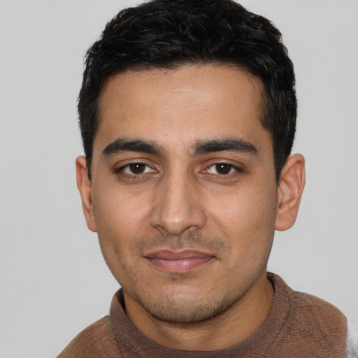 Joyful latino young-adult male with short  black hair and brown eyes