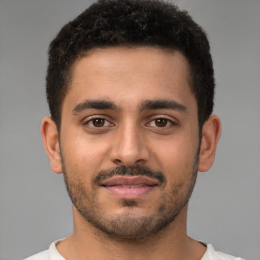 Joyful latino young-adult male with short  brown hair and brown eyes