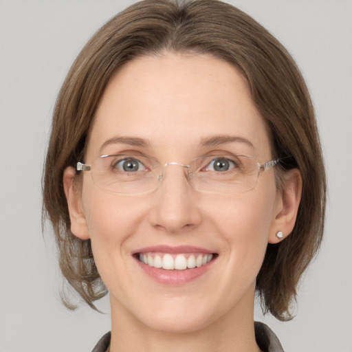 Joyful white adult female with medium  brown hair and grey eyes