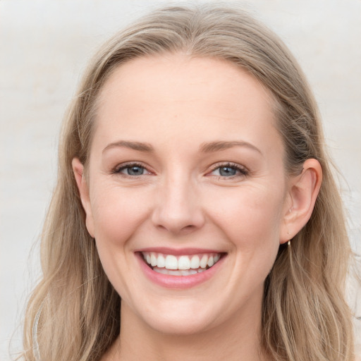 Joyful white young-adult female with long  brown hair and blue eyes