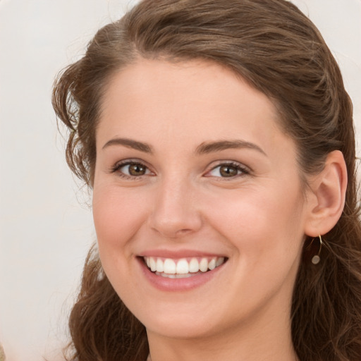 Joyful white young-adult female with long  brown hair and green eyes