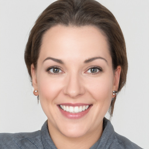 Joyful white young-adult female with medium  brown hair and grey eyes