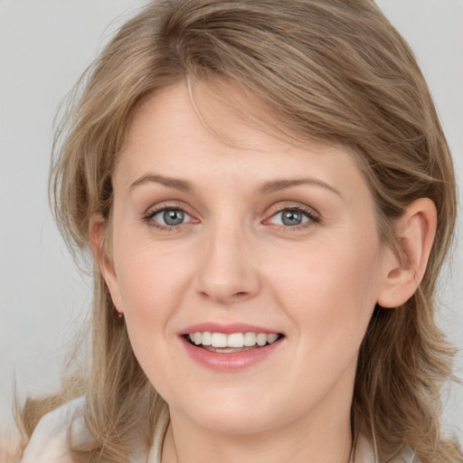 Joyful white young-adult female with medium  brown hair and blue eyes