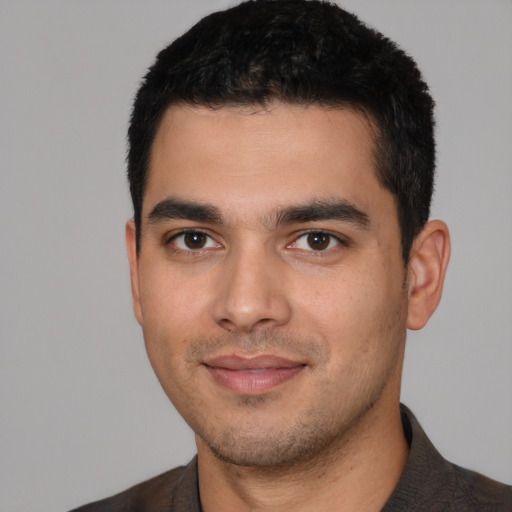Joyful white young-adult male with short  black hair and brown eyes