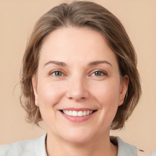 Joyful white young-adult female with medium  brown hair and green eyes