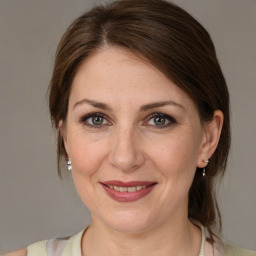 Joyful white adult female with medium  brown hair and grey eyes