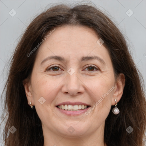 Joyful white adult female with long  brown hair and brown eyes