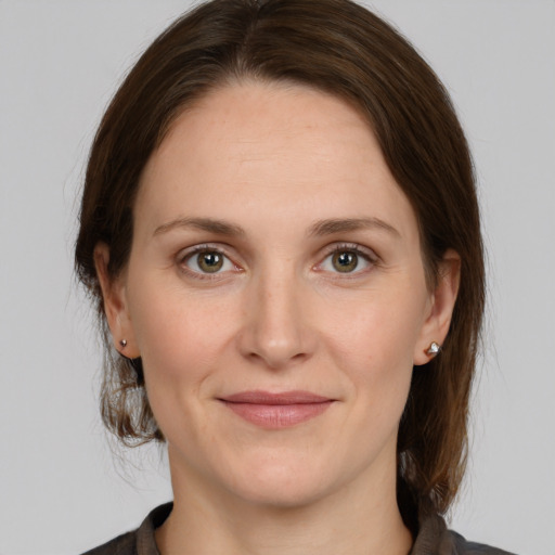 Joyful white young-adult female with medium  brown hair and grey eyes