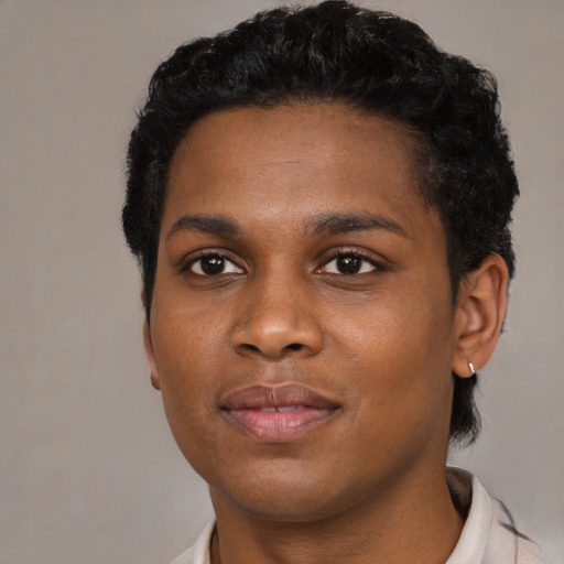Joyful black young-adult female with short  black hair and brown eyes