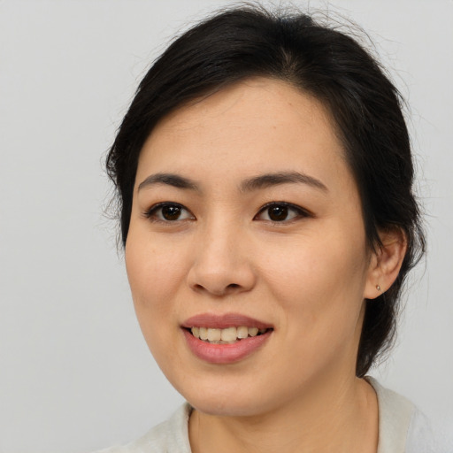 Joyful asian young-adult female with medium  brown hair and brown eyes