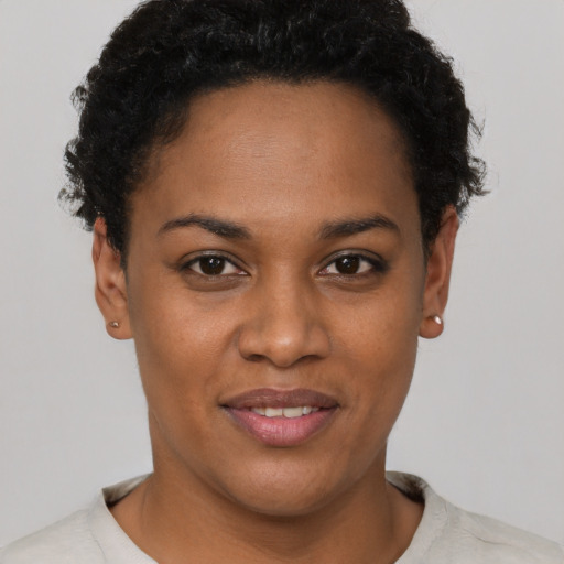 Joyful black young-adult female with short  brown hair and brown eyes