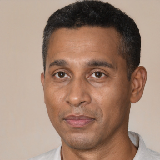 Joyful black adult male with short  black hair and brown eyes