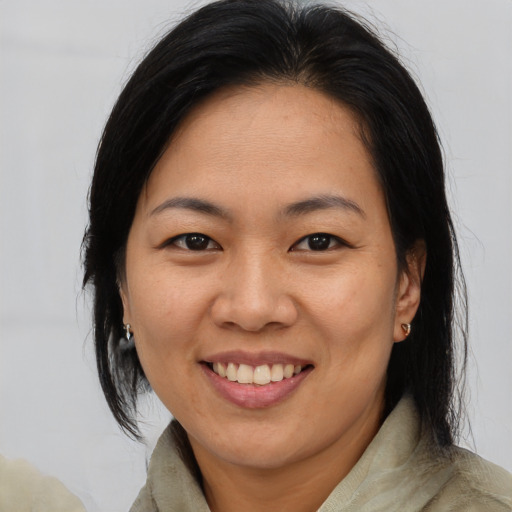Joyful asian adult female with medium  brown hair and brown eyes