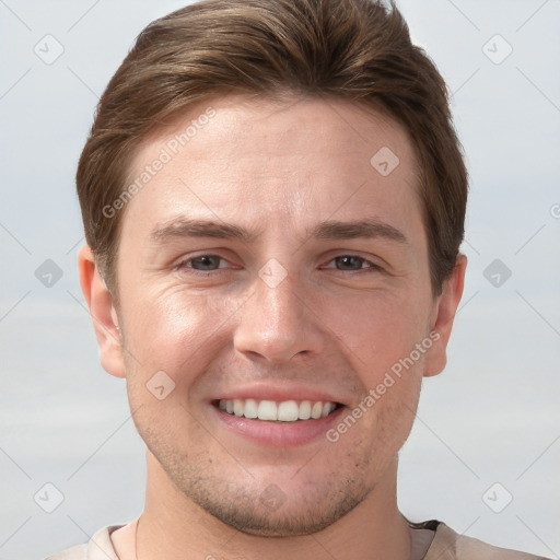 Joyful white young-adult male with short  brown hair and grey eyes