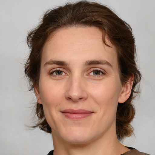 Joyful white young-adult female with medium  brown hair and green eyes