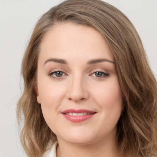 Joyful white young-adult female with long  brown hair and green eyes