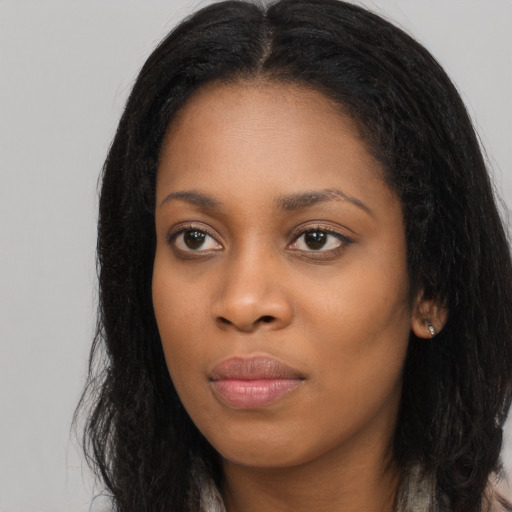 Joyful black young-adult female with long  black hair and brown eyes