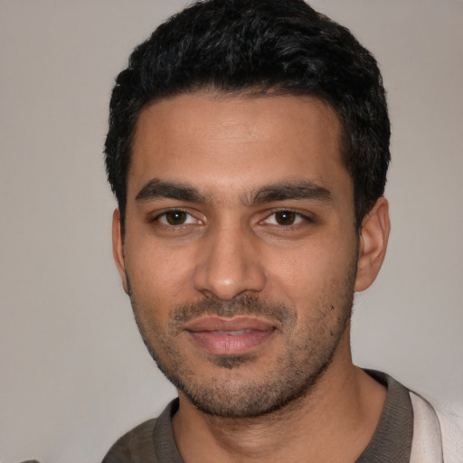 Joyful latino young-adult male with short  black hair and brown eyes