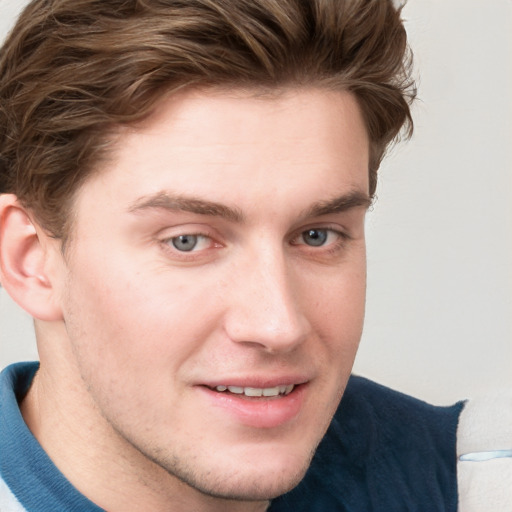 Joyful white young-adult male with short  brown hair and blue eyes