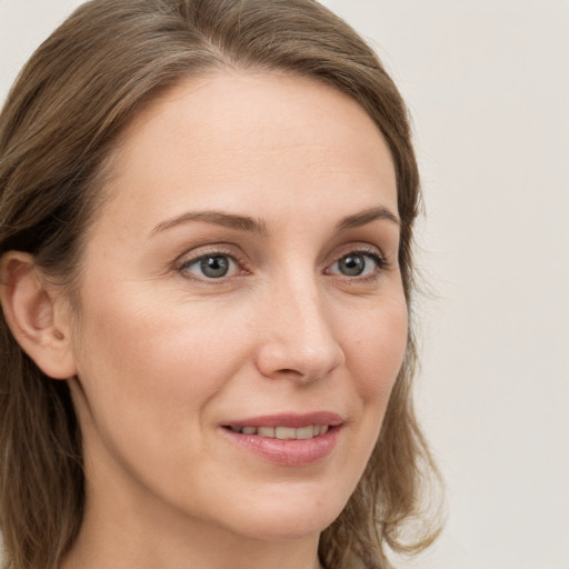 Joyful white young-adult female with long  brown hair and grey eyes