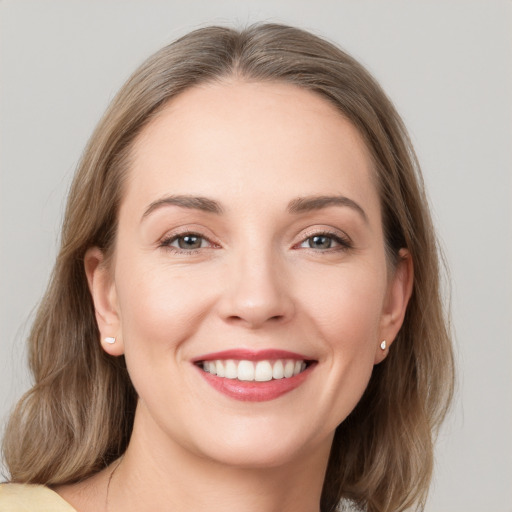 Joyful white young-adult female with medium  brown hair and grey eyes