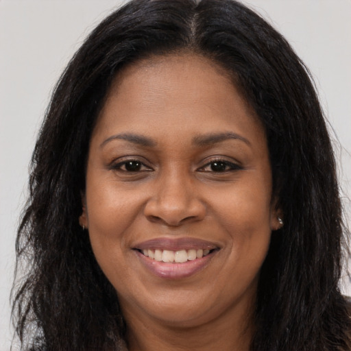 Joyful black adult female with long  brown hair and brown eyes