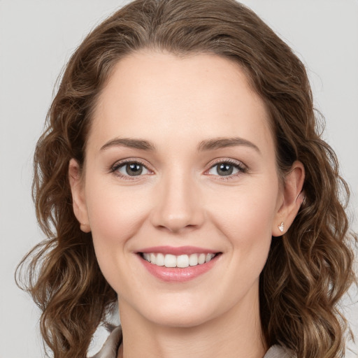 Joyful white young-adult female with long  brown hair and grey eyes