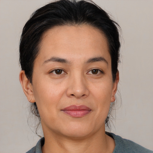 Joyful latino adult female with medium  brown hair and brown eyes