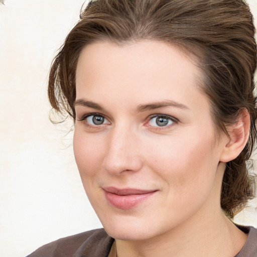 Joyful white young-adult female with medium  brown hair and grey eyes