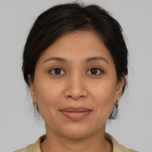 Joyful latino adult female with medium  brown hair and brown eyes