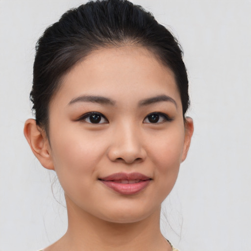 Joyful asian young-adult female with medium  brown hair and brown eyes