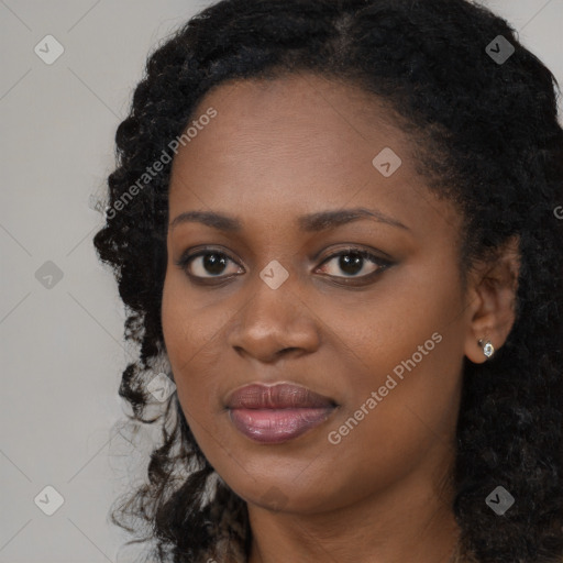 Joyful black young-adult female with long  black hair and brown eyes