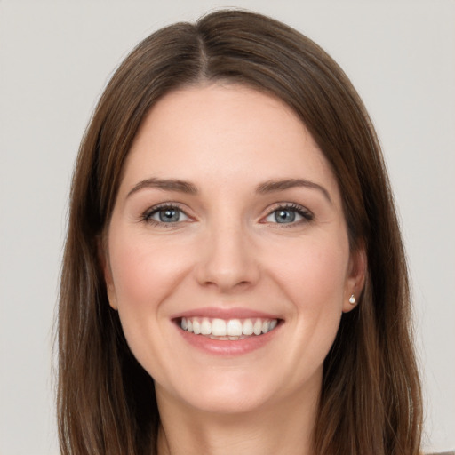 Joyful white young-adult female with long  brown hair and grey eyes