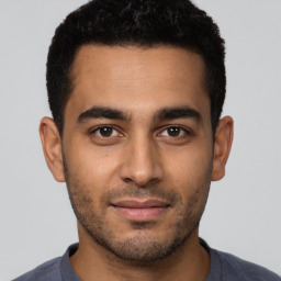 Joyful latino young-adult male with short  brown hair and brown eyes