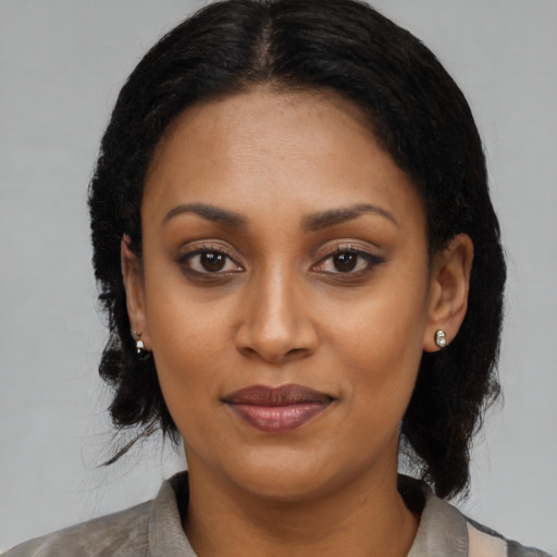 Joyful black young-adult female with medium  black hair and brown eyes
