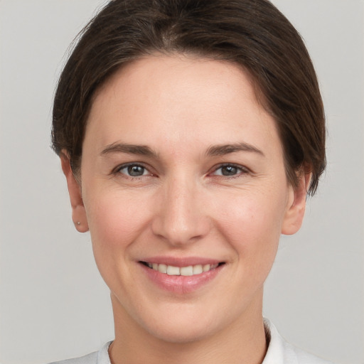 Joyful white young-adult female with short  brown hair and grey eyes