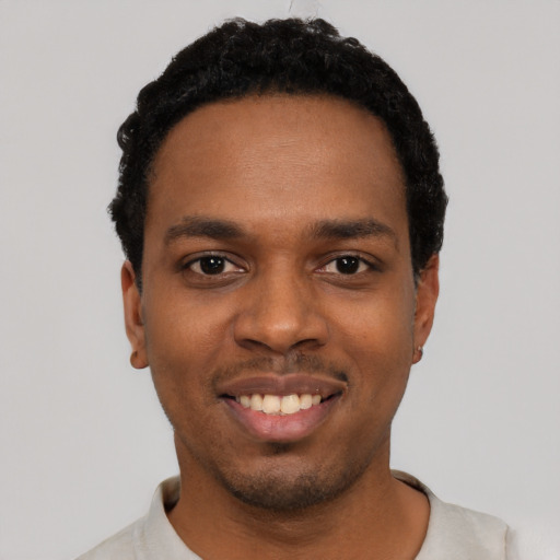 Joyful black young-adult male with short  black hair and brown eyes