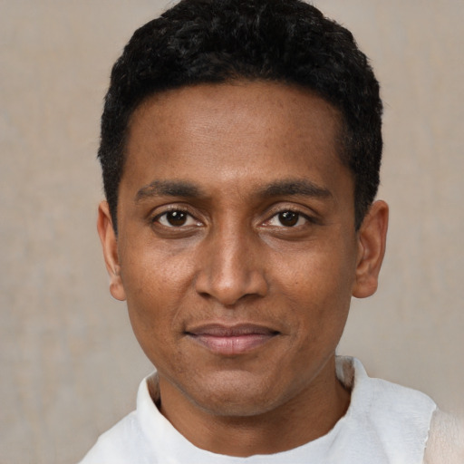 Joyful black young-adult male with short  black hair and brown eyes