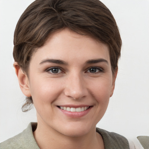 Joyful white young-adult female with short  brown hair and grey eyes