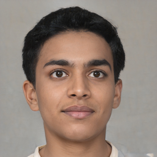 Joyful latino young-adult male with short  black hair and brown eyes