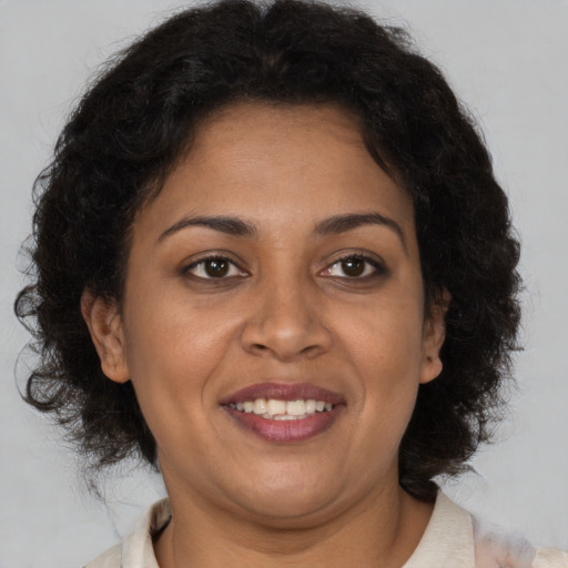 Joyful black adult female with medium  brown hair and brown eyes