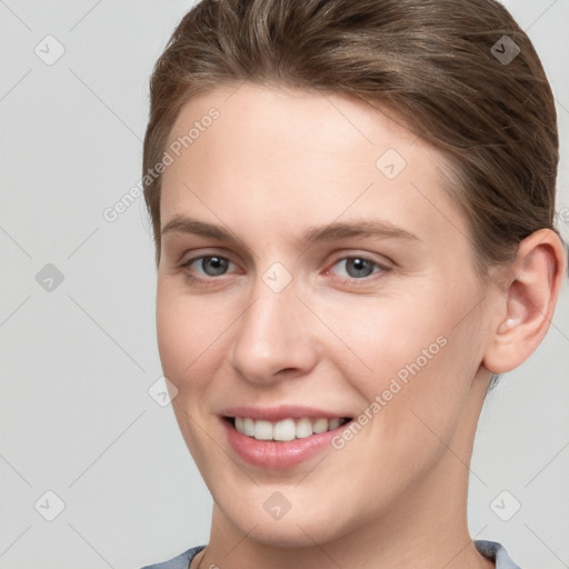 Joyful white young-adult female with short  brown hair and grey eyes