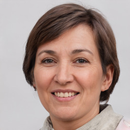 Joyful white adult female with medium  brown hair and grey eyes