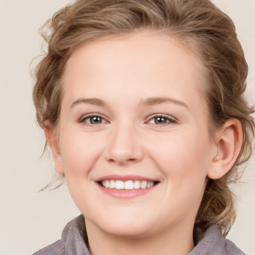 Joyful white young-adult female with medium  brown hair and blue eyes