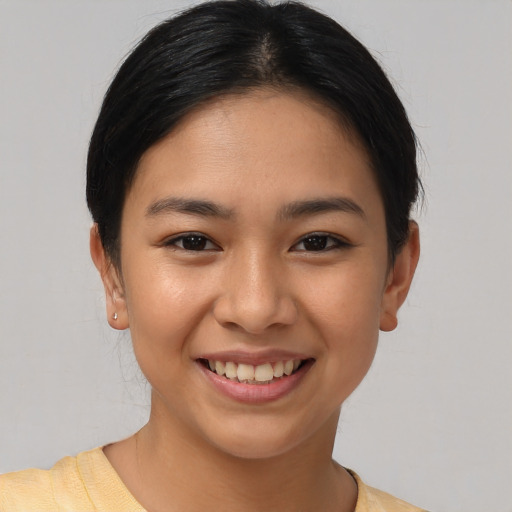 Joyful latino young-adult female with short  black hair and brown eyes
